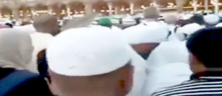 حاج يطوف في مكة المكرمة وعلى رأسه طير