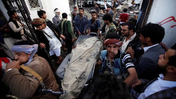 People carry the body of man killed in what witnesses said was an airstrike by Saudi-led coalition aircraft at a hall where a wake was being held, in Sanaa