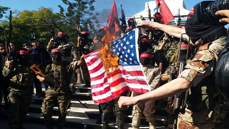 كتائب المقاومة تحرق العلم الأمريكي وتدعو للإنتفاضة